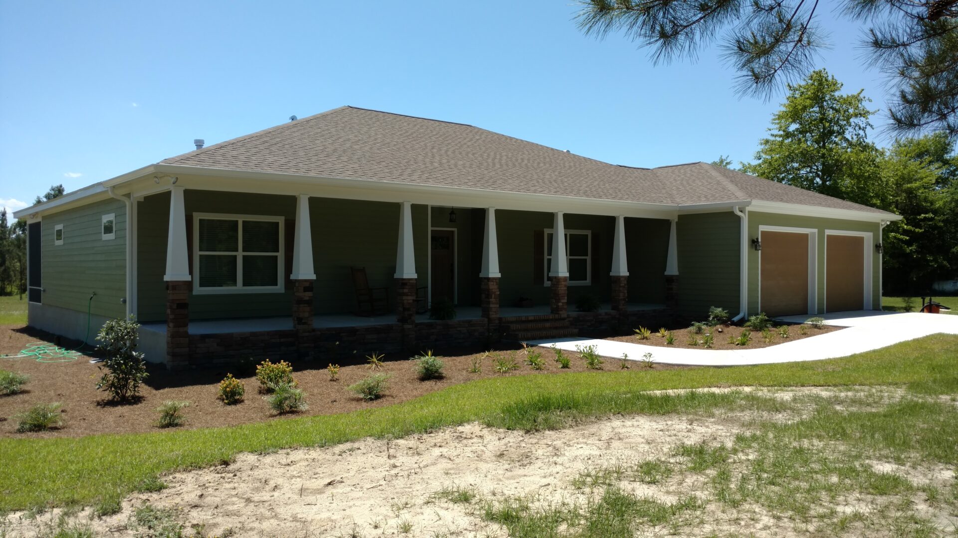 A large house with a lot of grass on the front lawn.