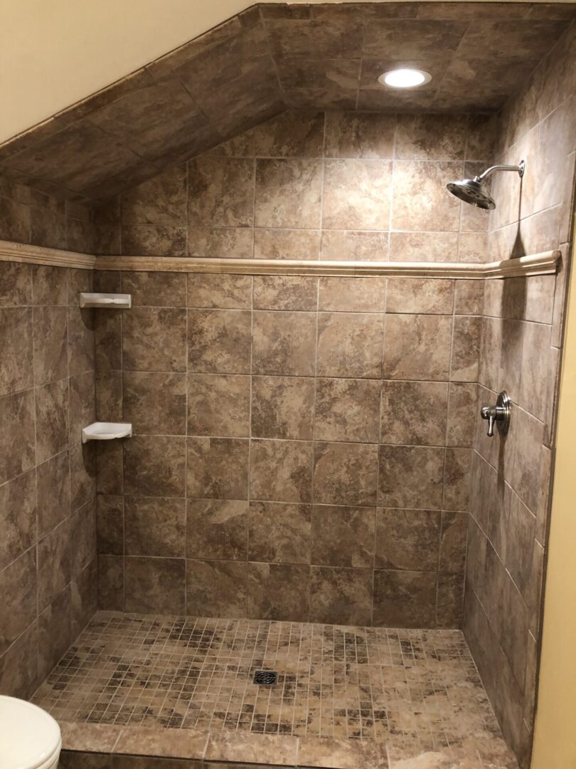 A tiled shower with no curtain and no door.