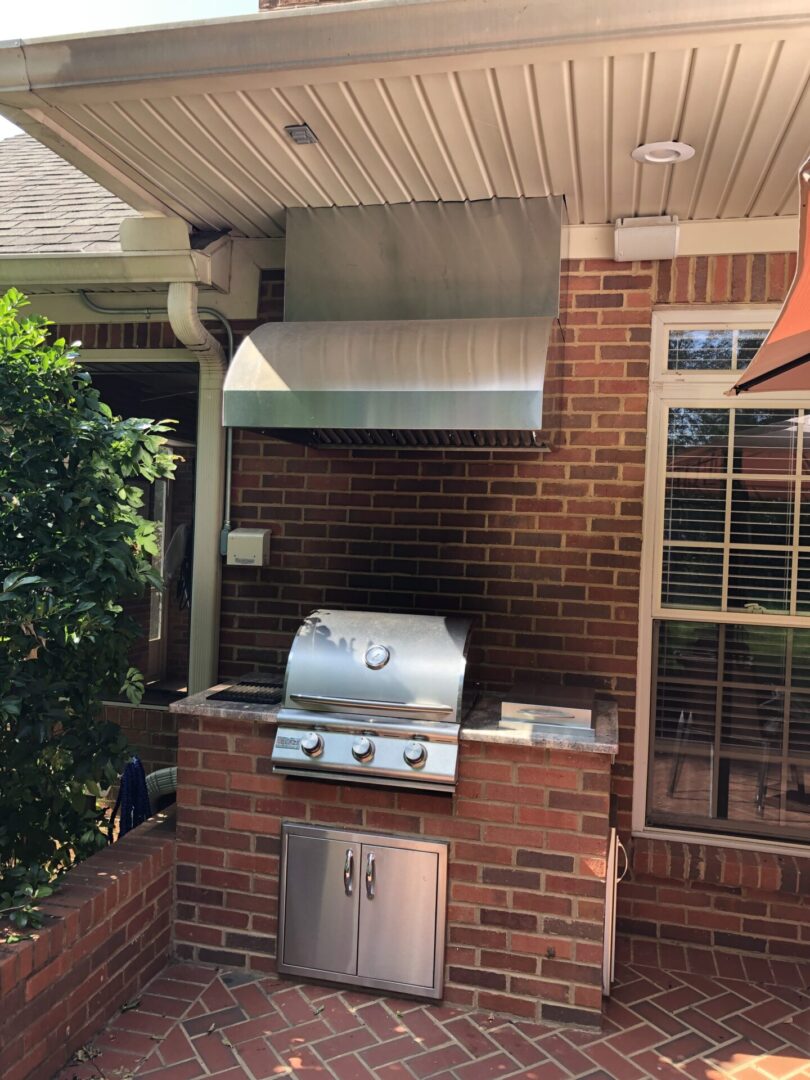 A grill on top of a brick wall.