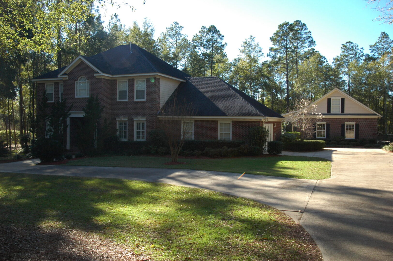 A large brick house with a driveway in front of it.